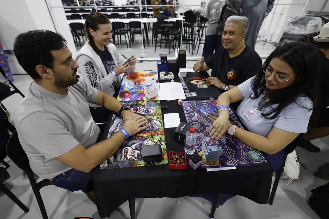 Players facing off across a trading card game table at tabletop.me